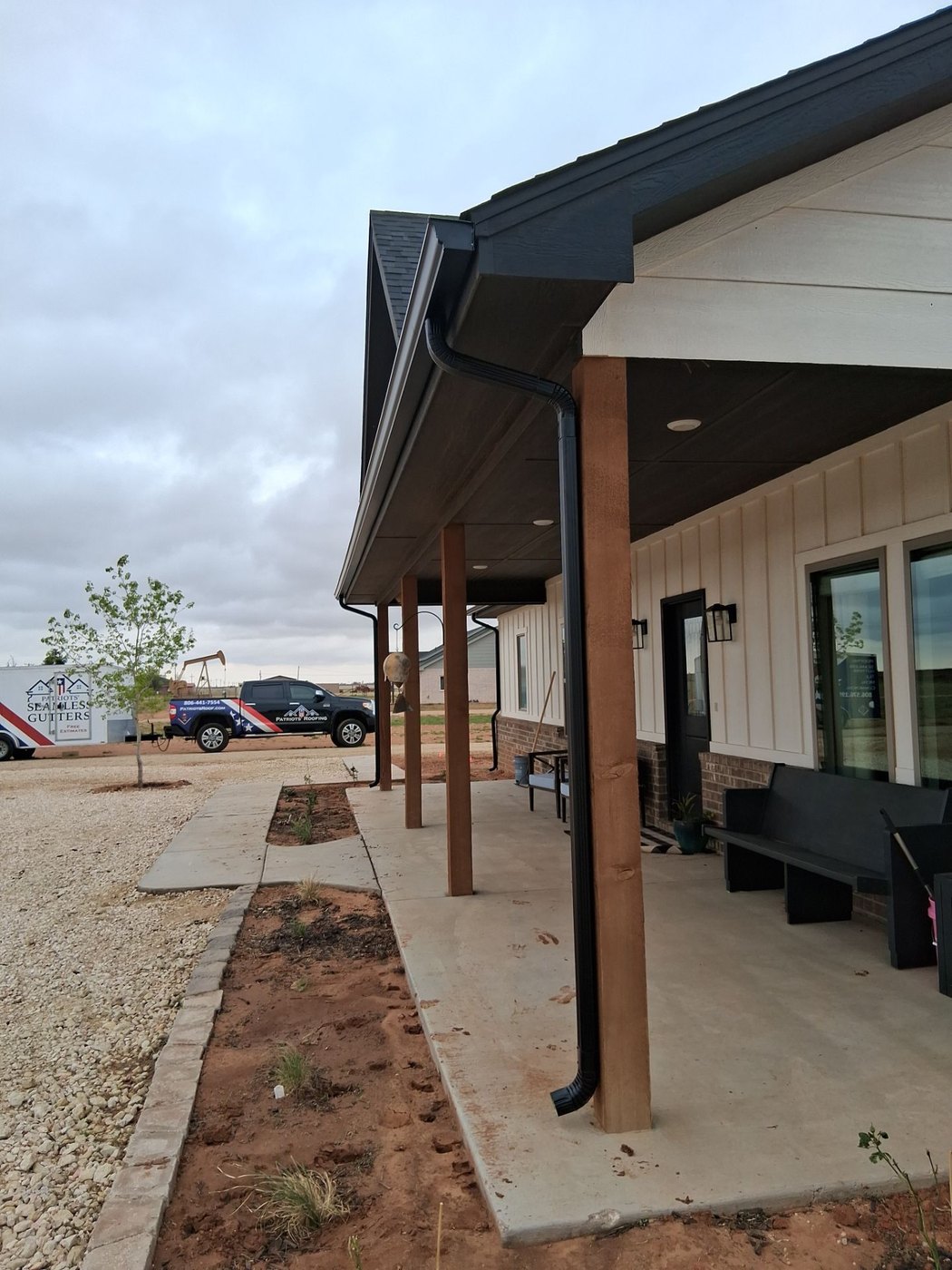 Black seamless gutters on a board-and-batten farmhouse near Lubbock